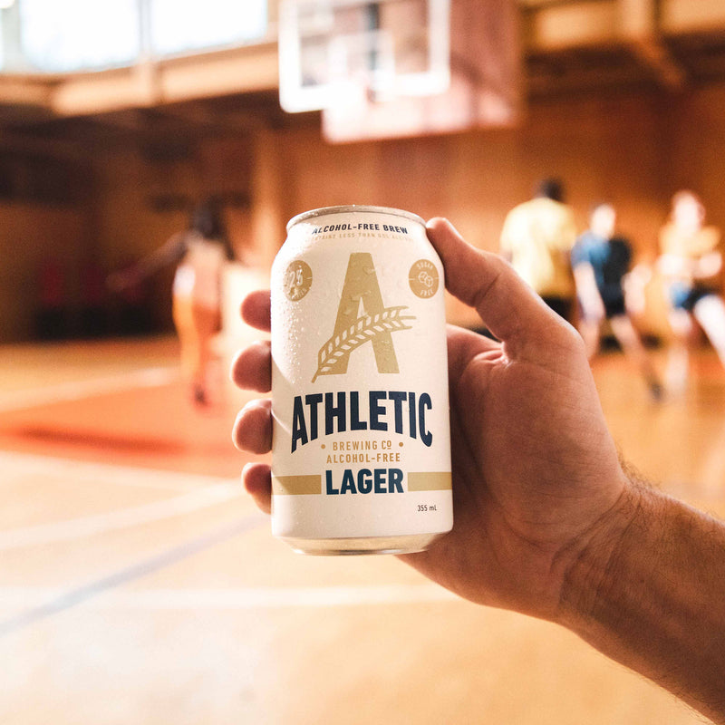holding athletic lager on basketball court